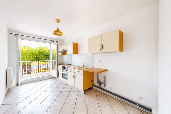 La cuisine vue vers la porte-fenêtre qui ouvre sur le balcon filant